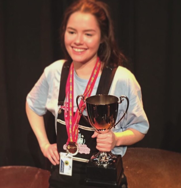 Julie med pokal etter å ha vunnet skole-NM i søm